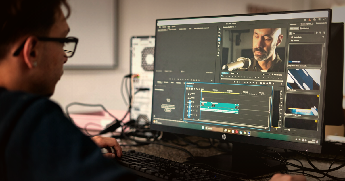 A video editor at a workstation editing wedding footage in a warm, cinematic edit suite